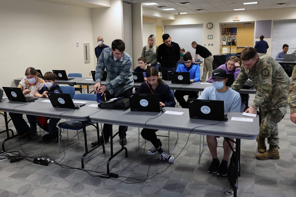 Hands-on cybersecurity training event with students working at laptops